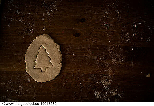 raw dough christmas tree cut out on wood table  flat lay