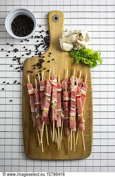 Raw meat skewers on cutting board