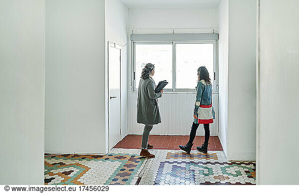 Real estate agent showing details to woman while standing in apartment