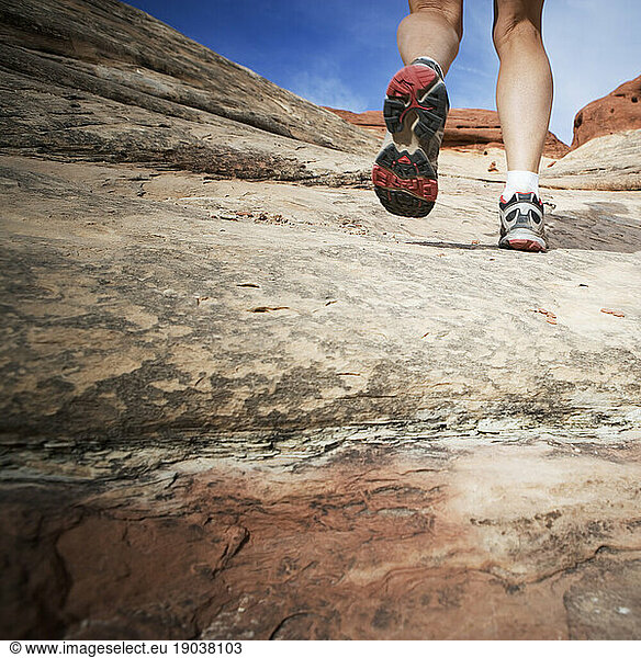 Rear low angle view of a female hikes feet  Canyonlands National Park  Utah.