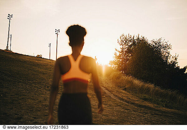 Rear view female athlete looking at sunset