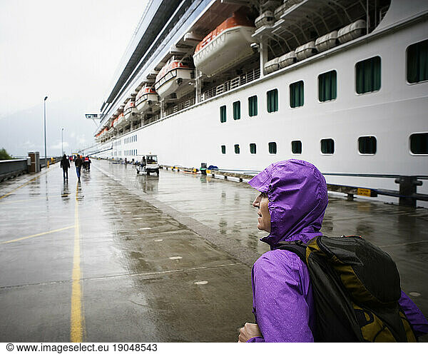 Rear view of a woman walking towards a docked cruise ship  Ketchikan  Alaska. USA.