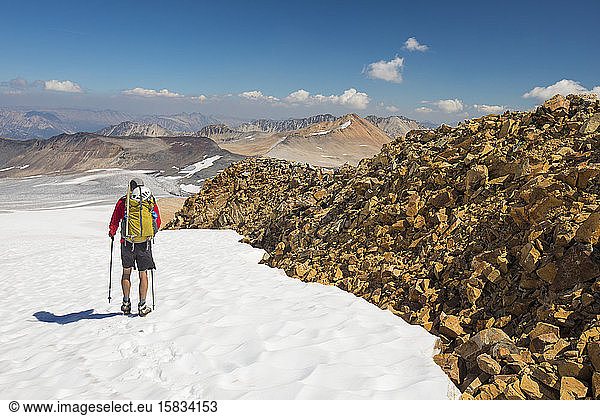 Rear view of backpacker exploring new terrain.