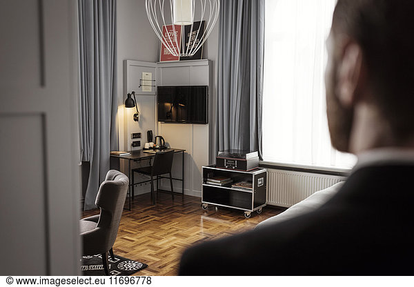 Rear view of businessman standing in hotel room