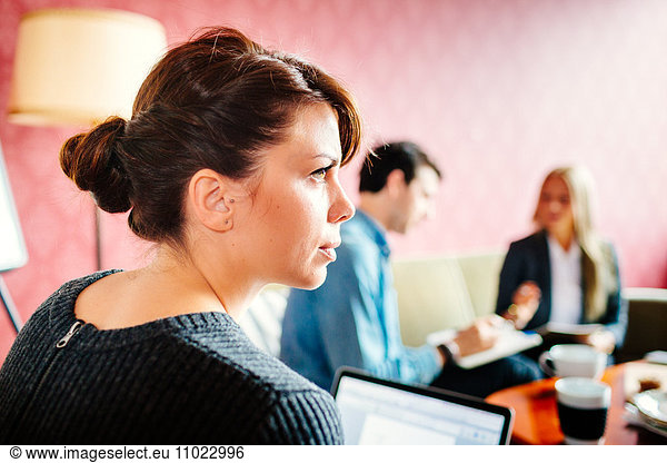 Rear view of businesswoman looking away during meeting in office