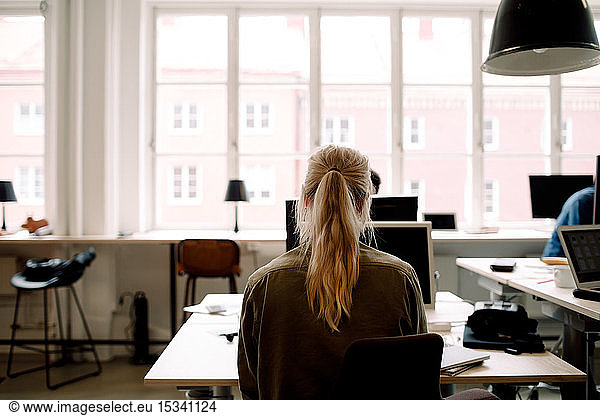 Rear view of businesswoman working in creative office