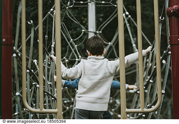 Rear view of children on climbing frame at playground