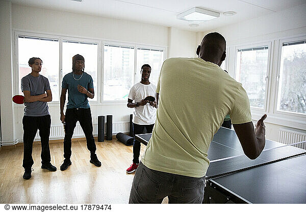 Rear view of coach conducting training sessions with students in games room