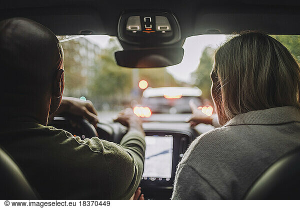 Rear view of couple traveling through car