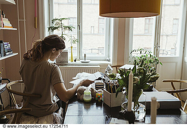 Rear view of female entrepreneur working at home office