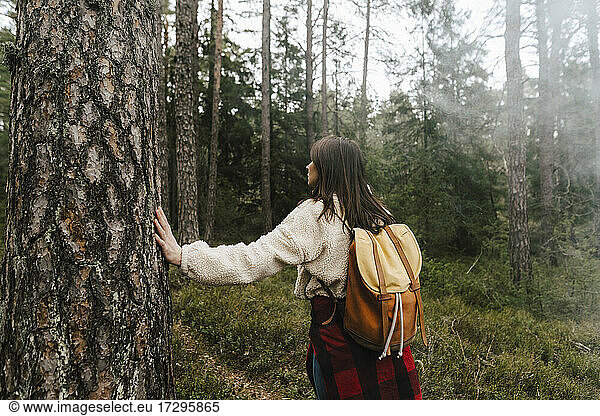 Rear view of female explorer walking in forest