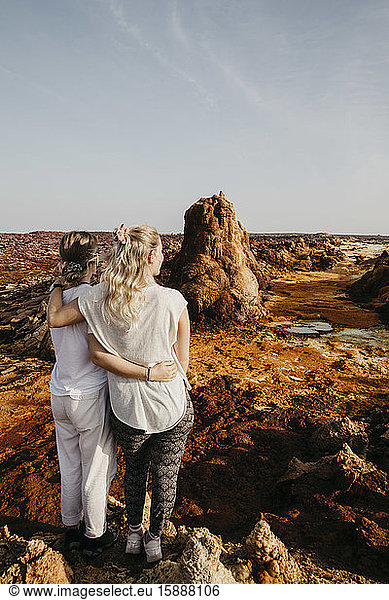 Rear view of female friends looking at volcanic landscape in Dallol Geothermal Area  Danakil Depression  Ethiopia  Afar