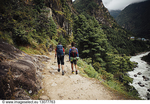 Rear view of friends with backpacks hiking at Sagarmatha National Park