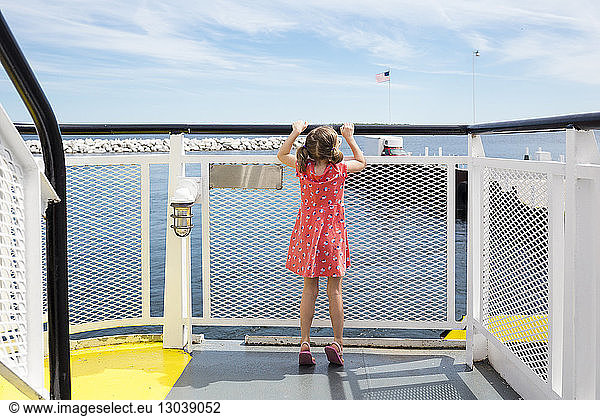 Rear view of girl looking through railing at Washington Island Ferry