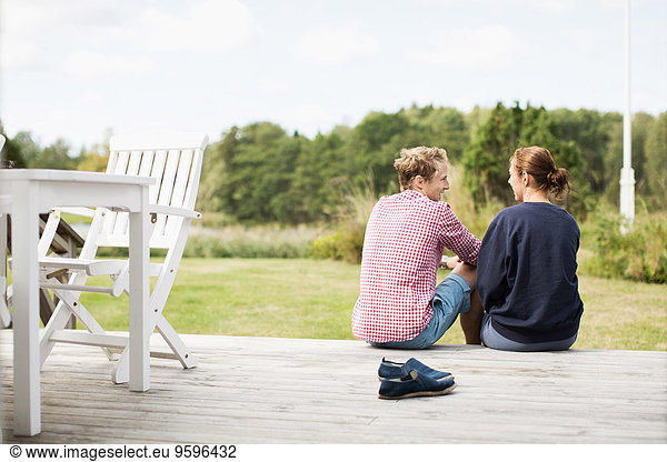 Rear view of happy mature couple communicating on porch