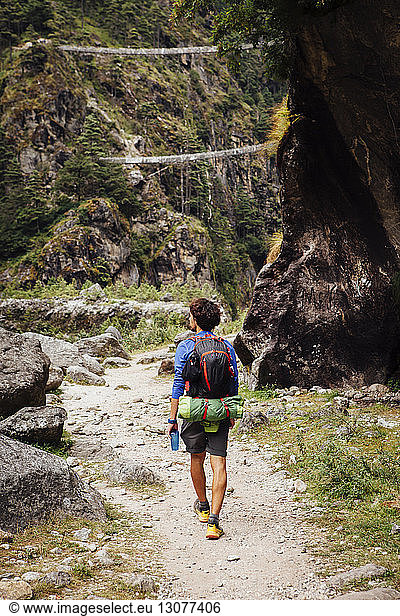 Rear view of hiker with backpack walking at Sagarmatha National Park