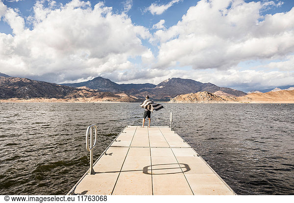 Rear view of man looking out from windy pier on Lake Isabella  California  USA