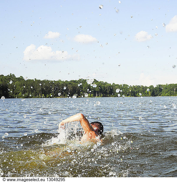 Rear view of man swimming in Lake Mackintosh against sky, Rear view of man swimming in Lake Mackintosh against sky