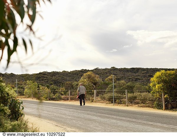 Rear view of man walking along road  Point Addis National Park  Anglesea  Australia