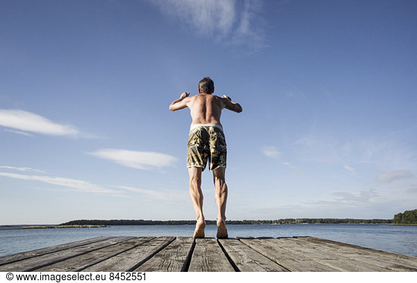 Rear view of mature man diving into sea