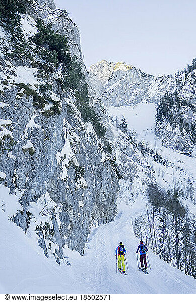 Rear view of men skiing on snow slope