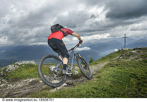 Rear view of mountain biker riding on uphill  Trentino-Alto Adige  Italy