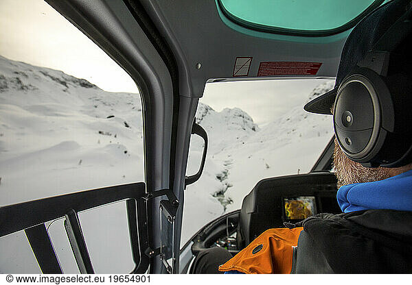 rear view of passenger looking out window of helicopter