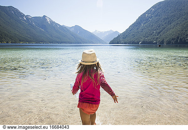 Rear view of toddler girl walking into Chilliwack Lake  B.C. Canada.