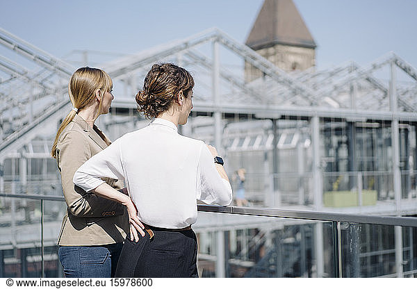 Rear view of two businesswomen standing at a greenhouse