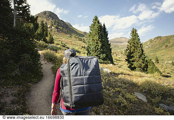 Rear view of woman hiking on mountain during summer