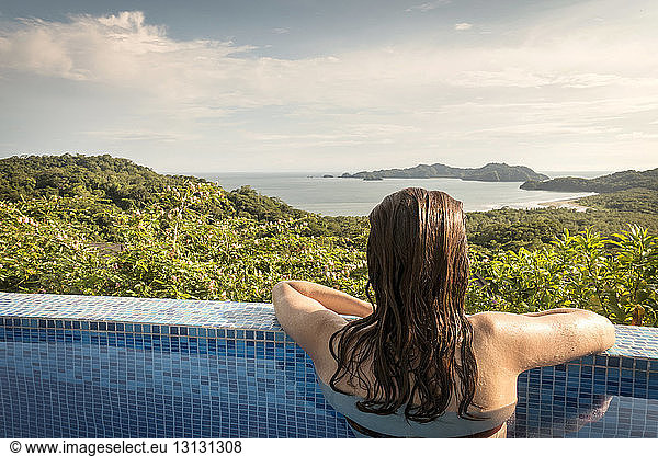 Rear view of woman in swimming pool enjoying view of Costa Rica