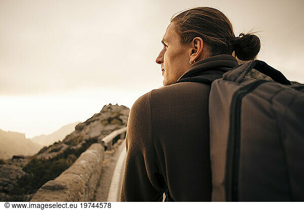 Rear view of young man with man bun looking away during vacation
