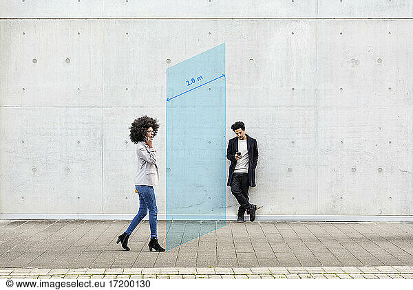 Rechteck  das die soziale Distanz zwischen einem Mann und einer Frau visualisiert  die im Freien ein Smartphone benutzen