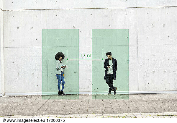Rechtecke zur Visualisierung sozialer Distanzierung  die einen Mann und eine Frau abdecken  die mit Smartphones in der Hand im Freien stehen