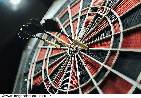 Red and black dartboard with darts