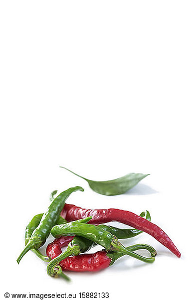 Red and green chilli peppers on white