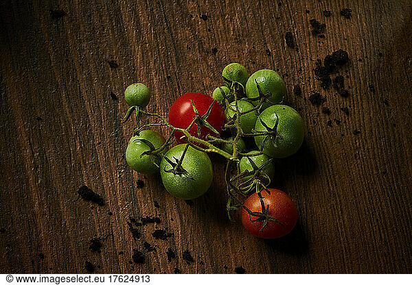 Red and green tomatoes lying on wooden surface