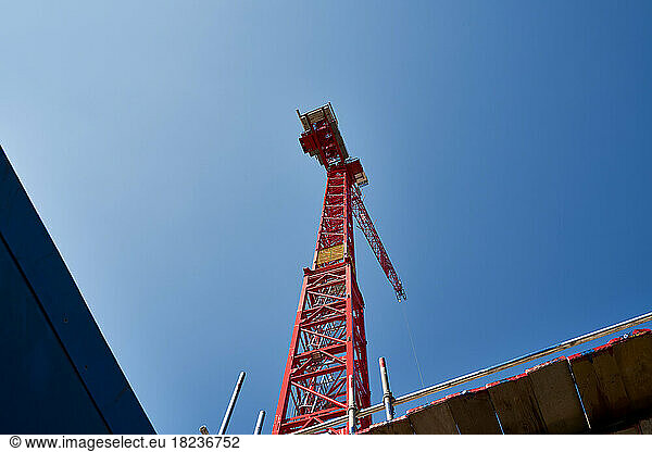 Red crane machinery under blue sky