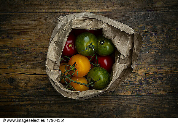 Red  green and yellow tomatoes in paper bag