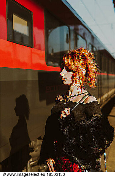 red-haired woman in train station waiting the train