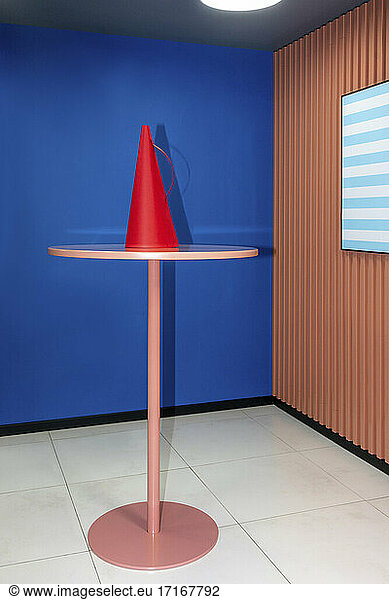 Red megaphone on table against blue wall at workplace