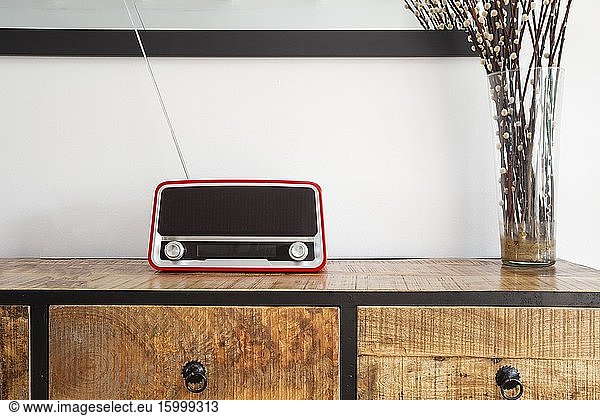 Red retro radio player on wooden closet in a living room  modern decoration closeup.