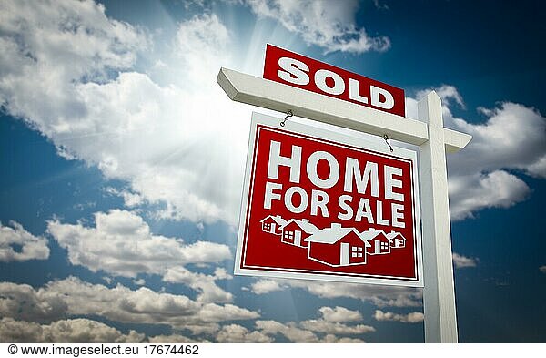 Red sold home for sale real estate sign over beautiful clouds and blue sky