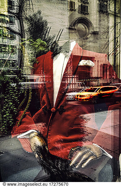 Red suit on mannequin seen through store window with reflection of building  New York  USA