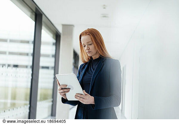 Redhead businesswoman using tablet PC at office