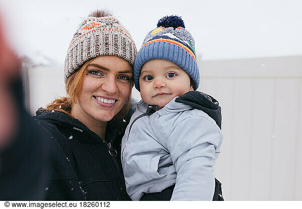 Redhead mom and baby taking selfie outside in winter snow in uta