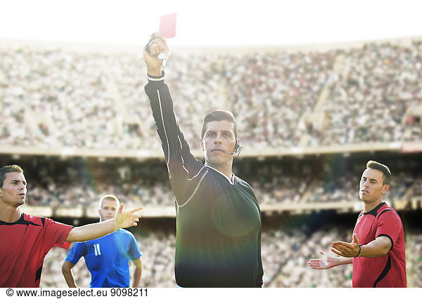 Referee flashing red card in soccer game