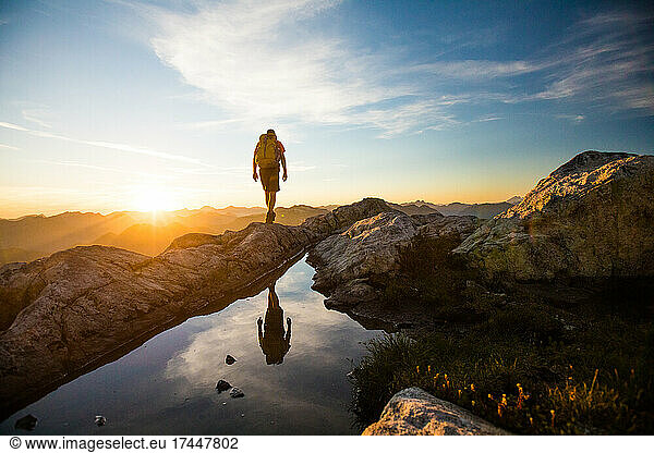 reflected view of backpacker hiking on mountain rige.