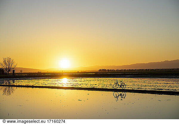 Reflection of bicycle seen at Ebro Delta during sunset  Spain