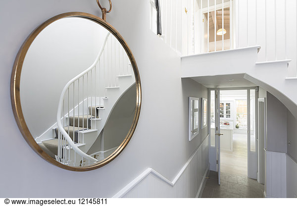 Reflection of foyer staircase in round mirror